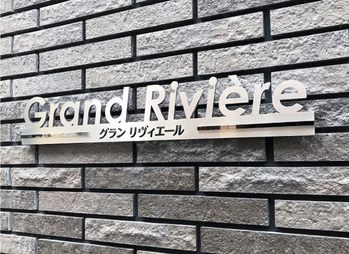 繋がった切り文字サイン　ステンレス切り文字銘板　マンションの看板